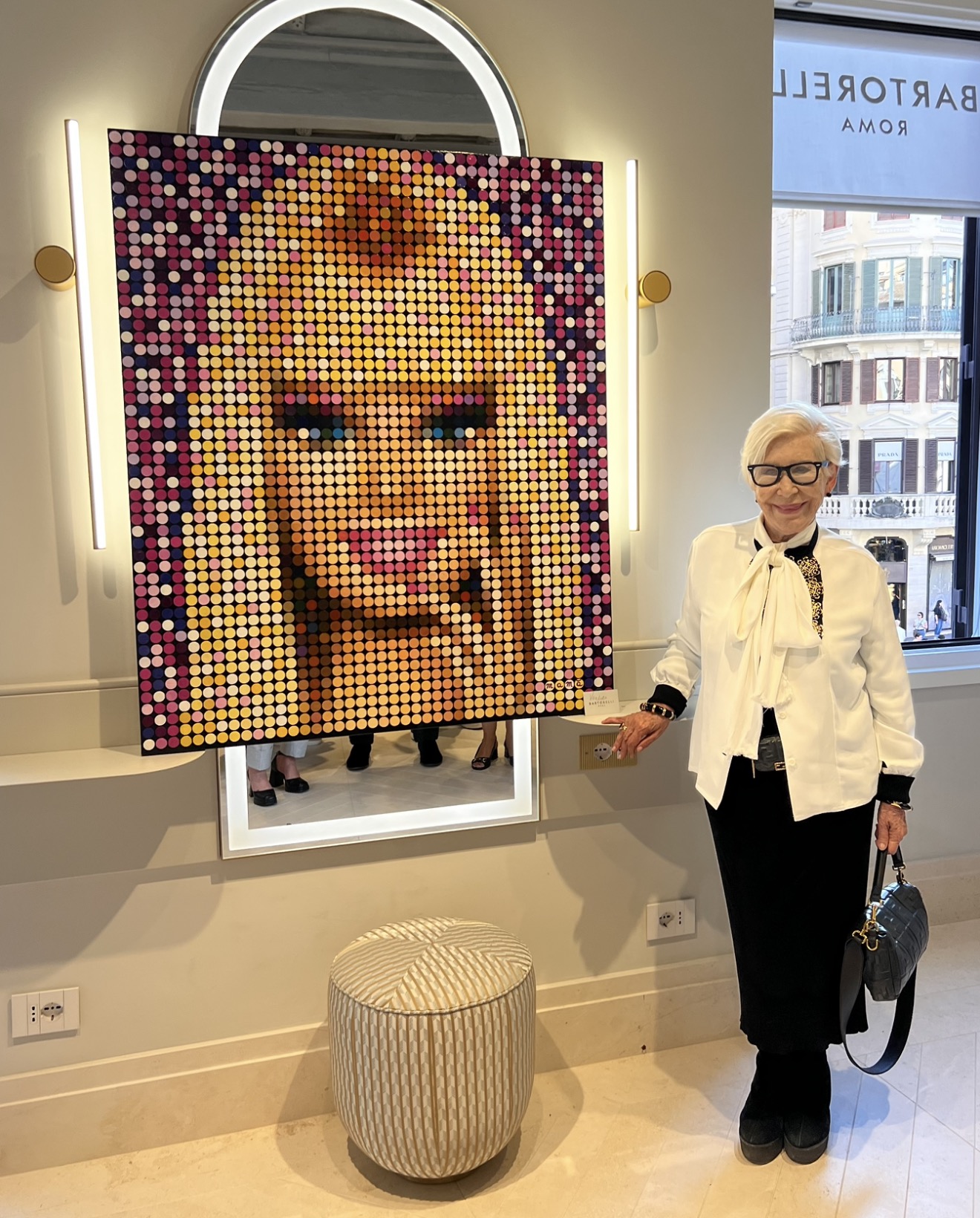 A longtime Bartorelli client beside a custom portrait artwork in the Piazza di Spagna salon