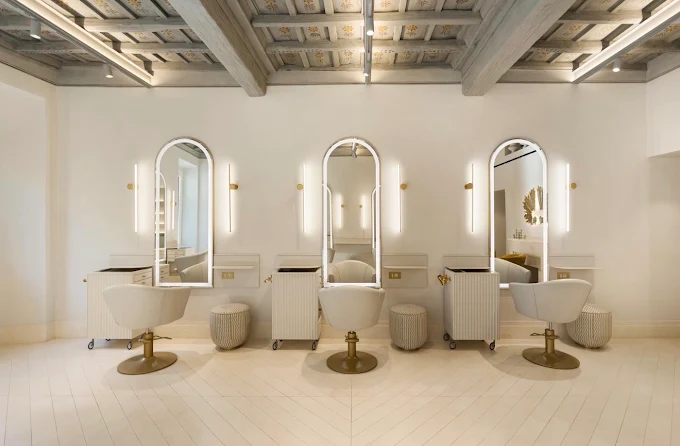 Three arched mirror styling stations beneath a hand-painted frescoed ceiling